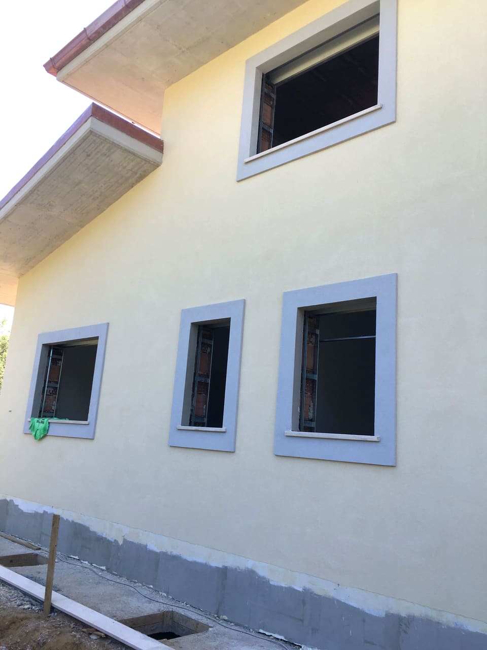 Facciata intonacata di una villa con finestre dalle cornici grigie