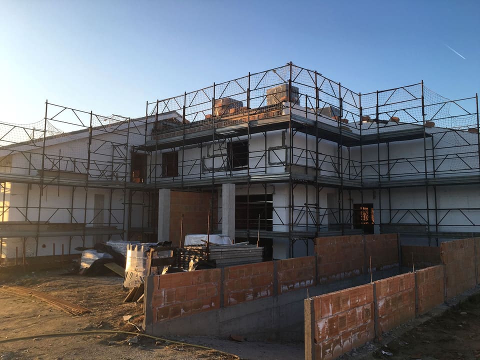 Edificio a due piani con ponteggi e murature in laterizio