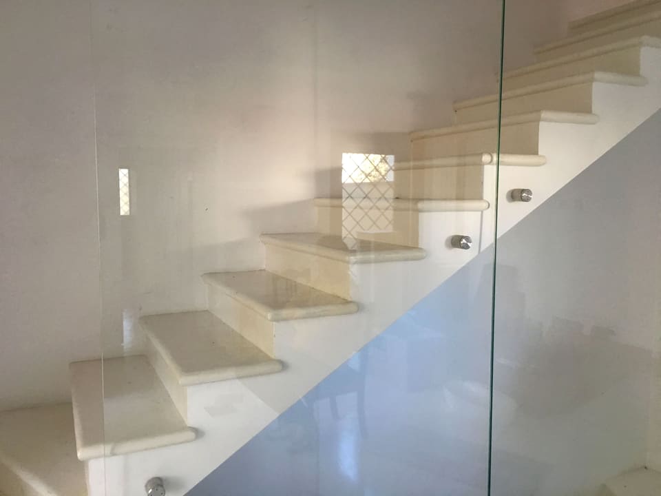 Scala interna in marmo bianco con parapetto in vetro